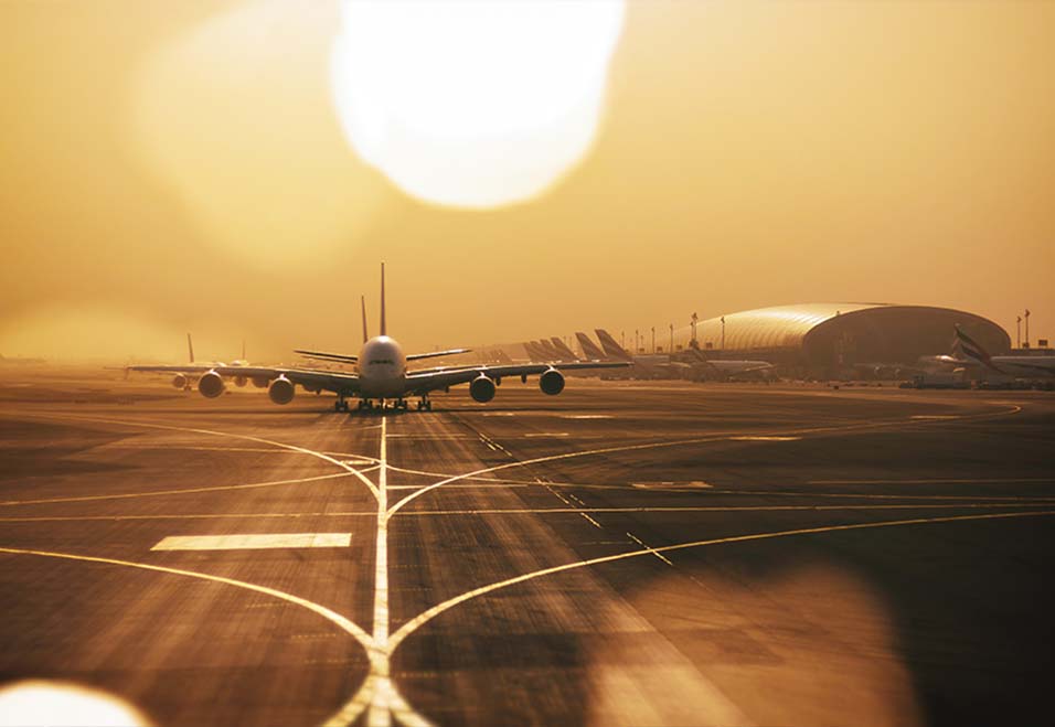 Far away aeroplane on the runway during sunset
